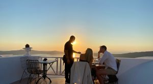 Couple sit eating dinner in Santorini
